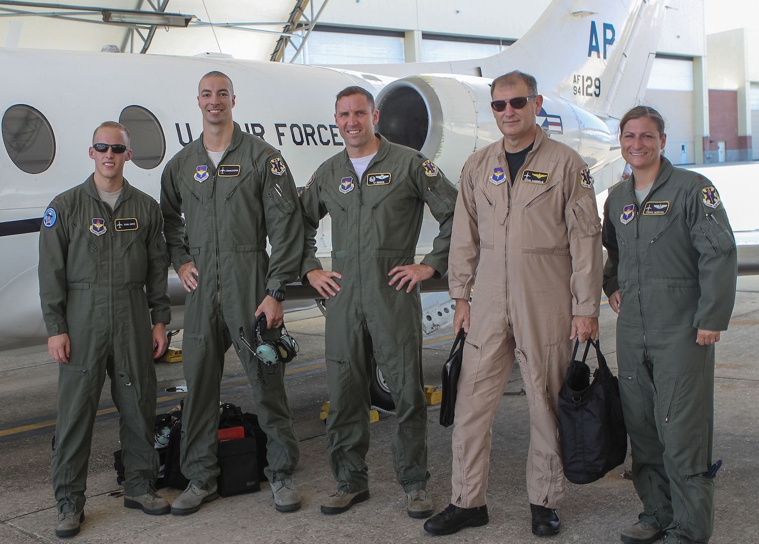 Second Lts. Chad James and Jeremy Mooney, Lt. Col. Timothy Moser, Mr. Kevin Salonman, and Maj. Carrie Register, all of the 451st Flying Training Squadron, pose for a photo in front of a modified T-1 Jayhawk aircraft before its first flight June 4, 2013 at Naval Air Station Pensacola, Fla. The aircraft has been modified for electronic warfare training, marking the first time in Air Force history that an undergraduate aviation program has formally incorporated the fundamentals of electronic warfare in flight into their syllabus. (U.S. Air Force photo by Master Sgt. Michelle Alexander)