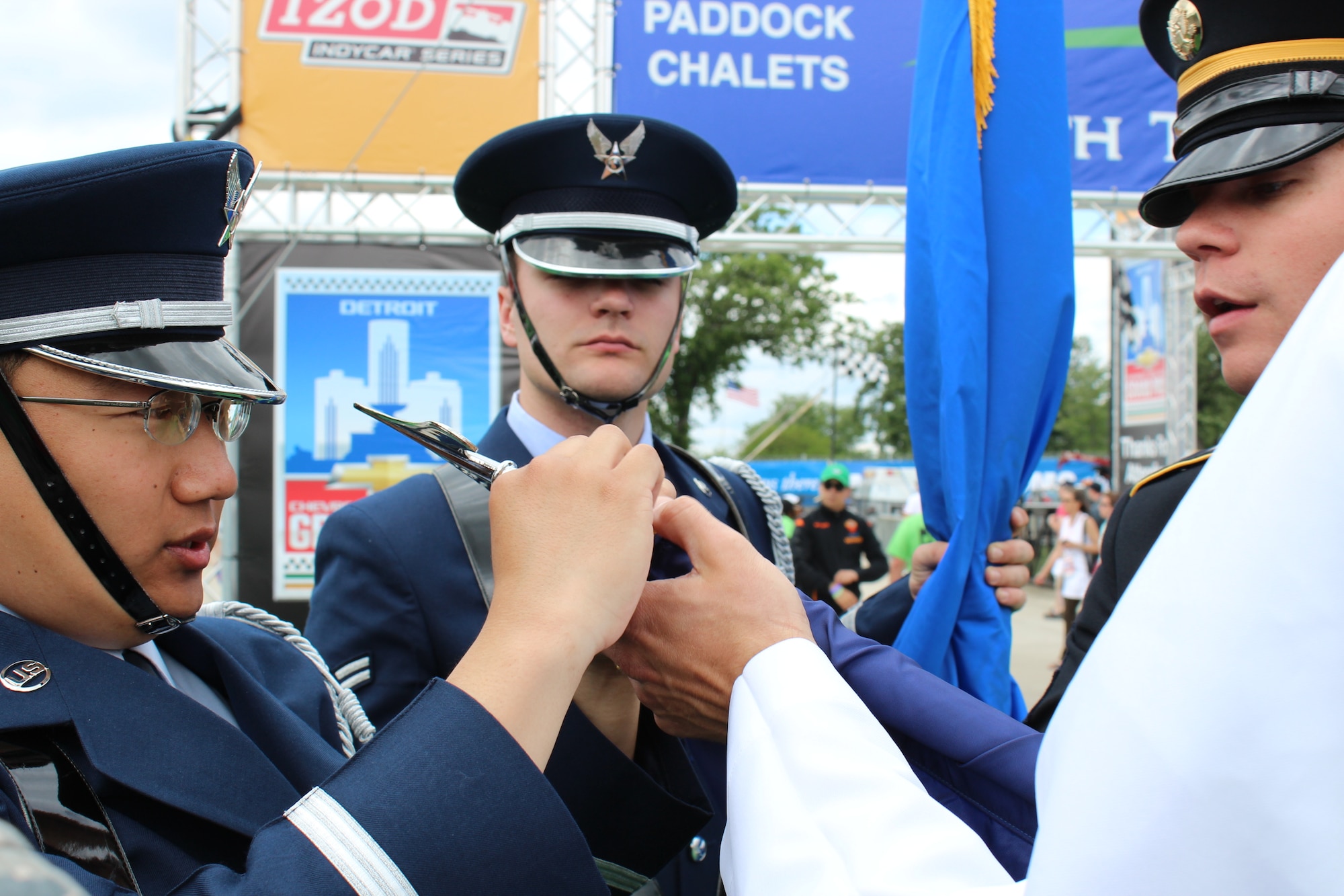 130601-Z-NV943-118: Honor Guard members from the Air Force, Navy and Army work together to secure a flag before presenting the colors during pre-race festivities on June 2, 2013, during the 2013 Chevrolet Detroit Belle Isle Grand Prix. More than 50 military members from the various branches and units at Selfridge Air National Guard Base, Mich., took part in five volunteer events over the race weekend. Grand Prix officials invited the military members to participate in the events to show their appreciation for their service. (U.S. Air National Guard photo by Angela Pope/Released)