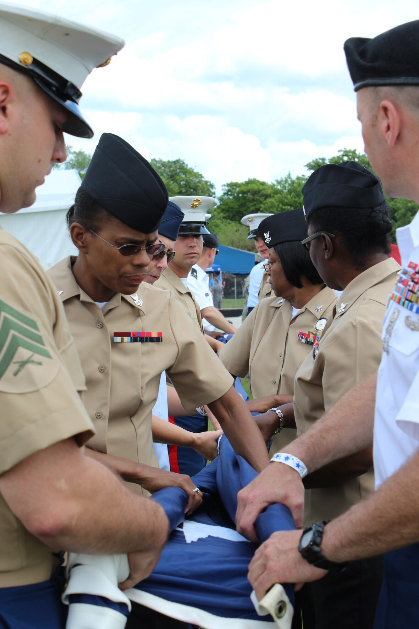 130601-Z-NV943-052: Marines, Soldiers, Sailors and Airmen from Selfridge Air National Guard Base, Mich., furl a large U.S. flag prior to the start of a race on June 1, 2013, during the 2013 Chevrolet Detroit Belle Isle Grand Prix. More than 50 military members from the various branches and units at Selfridge took part in five volunteer events over the race weekend. Grand Prix officials invited the military members to participate in the events to show their appreciation for their service. (U.S. Air National Guard photo by Angela Pope/Released)