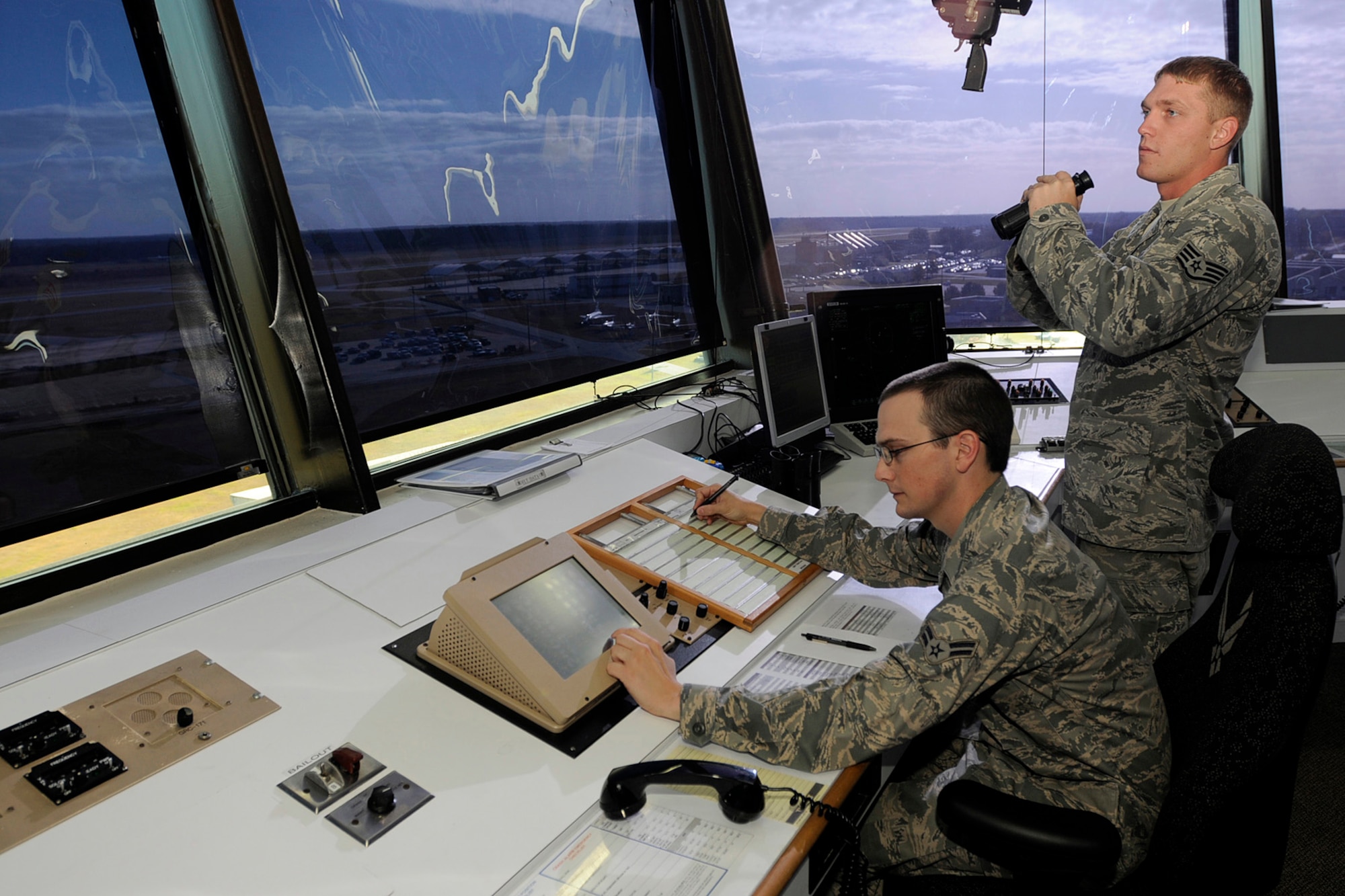 U.S. Air Force Staff Sgt. David Kaylor and Airman 1st Class Quinton Garvin, air traffic controllers with the 245th Air Traffic Control Squadron at McEntire Joint National Guard Base, South Carolina Air National Guard, watch for airfield activity from the control tower on Nov. 6, 2011.(U.S. Air National Guard photo by Tech. Sgt. Caycee Watson)