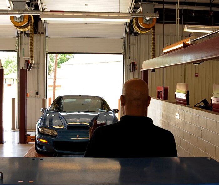Tim Jackson, Auto Hobby Shop manager, guides a customer's vehicle onto a lift on Barksdale Air Force Base, La., June 3, 2013.  Do-it-yourselfers can use the Auto Hobby Shop's 10 maintenance bays to change oil, tires, engines and more with free advice from on-staff certified mechanics. (U.S. Air Force photo/Staff Sgt. Jason McCasland)