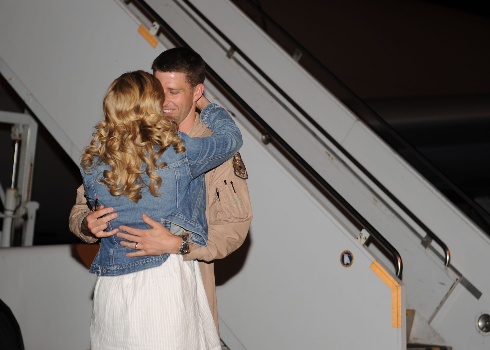 From right, Capt. Austin Noble, 351st Air Refueling Squadron KC-135 pilot, embraces his wife, Lindsey Noble, after returning from a deployment to Moron Air Base, Spain, June 3, 2013, at RAF Mildenhall, England. Noble arrived to find his wife and parents waiting to surprise him. (U.S. Air Force photo by Airman 1st Class Preston Webb/Released)