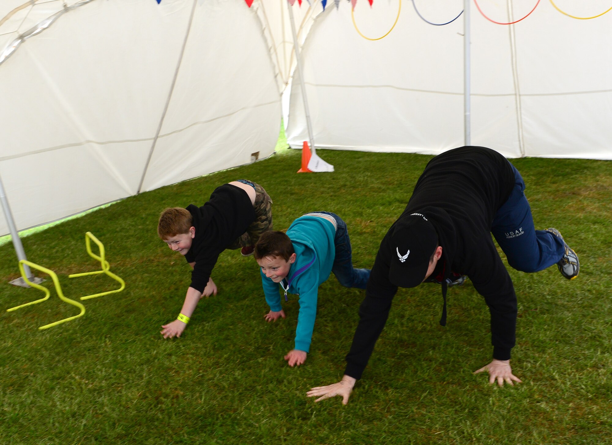 IPSWICH, England -- Tech. Sgt. Timmy Odom, 48th Aerospace Medicine Squadron health and wellness center NCO in charge, teaches Max Redstall (left), son of Sam Redstall, and Reyes Pearson (center), son of Rebecca Pearson, how to do the bear crawl during a Kids on the Move demonstration at the Suffolk Show May 30, 2013. The 48th AMDS Public Health office and HAWC worked with Healthy Ambitions to promote and educate families to live a healthy lifestyle. (U.S. Air Force photo by Staff Sgt. Stephanie Mancha)