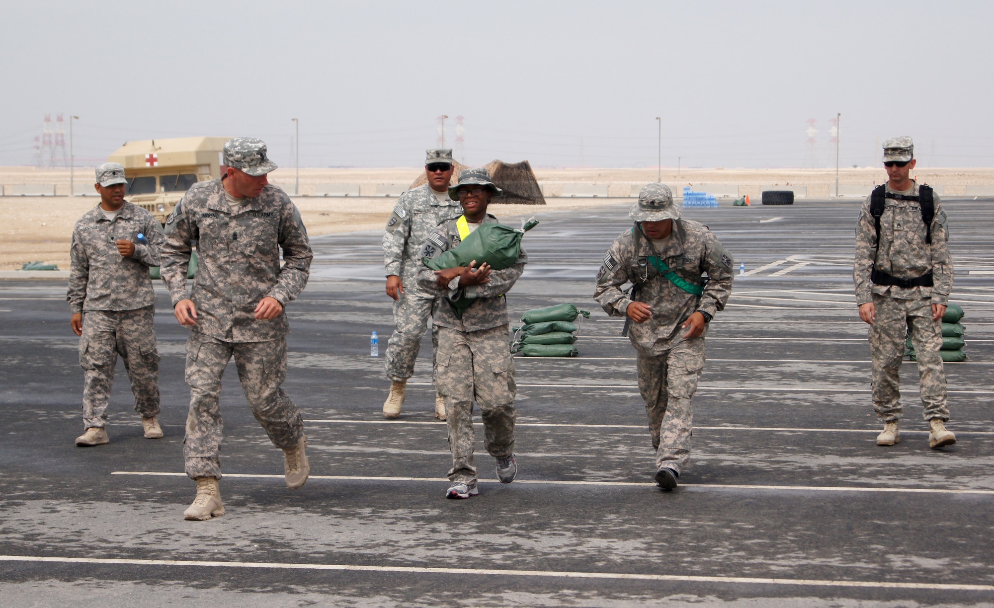 Echo Company 1st Sgt. Christopher Moreno motivates Pfc. Sharon Douglas as she endures the final leg of the recent “Tough Cobra” event at the 379th Air Expeditionary Wing in Southwest Asia. This event was all part of the 1-43 Air Defense Artillery Battalion’s “Best Cobra Competition.” (U.S. Army photo/Sgt. Daniel J. Baylor)