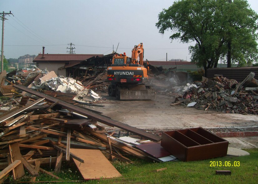 An excavator operator tears down the remaining section of the old base operations hub, Bldg. 882, at Osan Air Base, Republic of Korea, June 3, 2013. Bldg. 882 was the first of three buildings scheduled to be demolished due to the 51st Operations Support Squadron airfield operations flight relocating from three separate facilities into one. (Courtesy Photo)