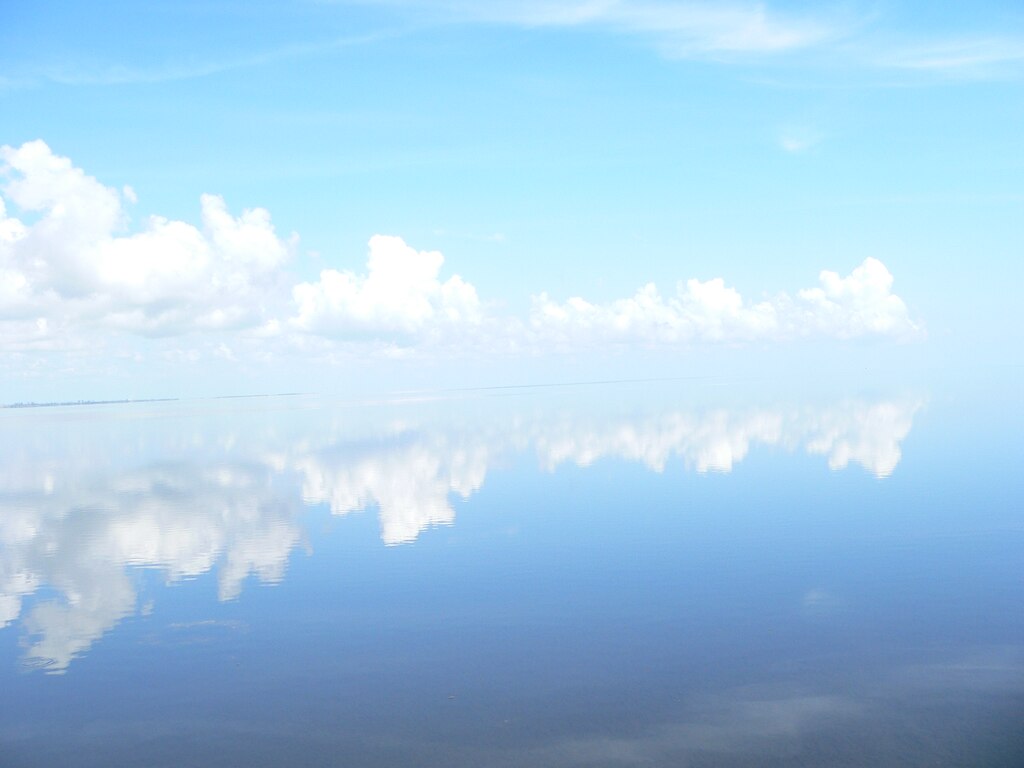 On summer afternoons, there is often a ring of clouds around Lake Okeechobee, and sometimes, it looks like the water meets the sky as the horizon on the big lake seems to disappear. 