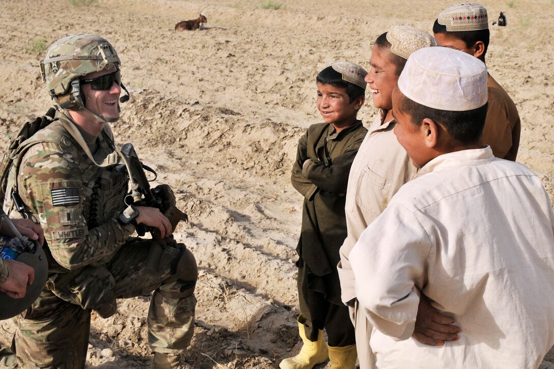U.S. Army 1st. Lt. James Whitler speaks with Afghan children during a dismounted presence patrol near Forward Operating Base Spin Boldak in Kandahar province, Afghanistan, June 2, 2013. Whitler is assigned to Company B, 2nd Battalion, 23rd Infantry Regiment.