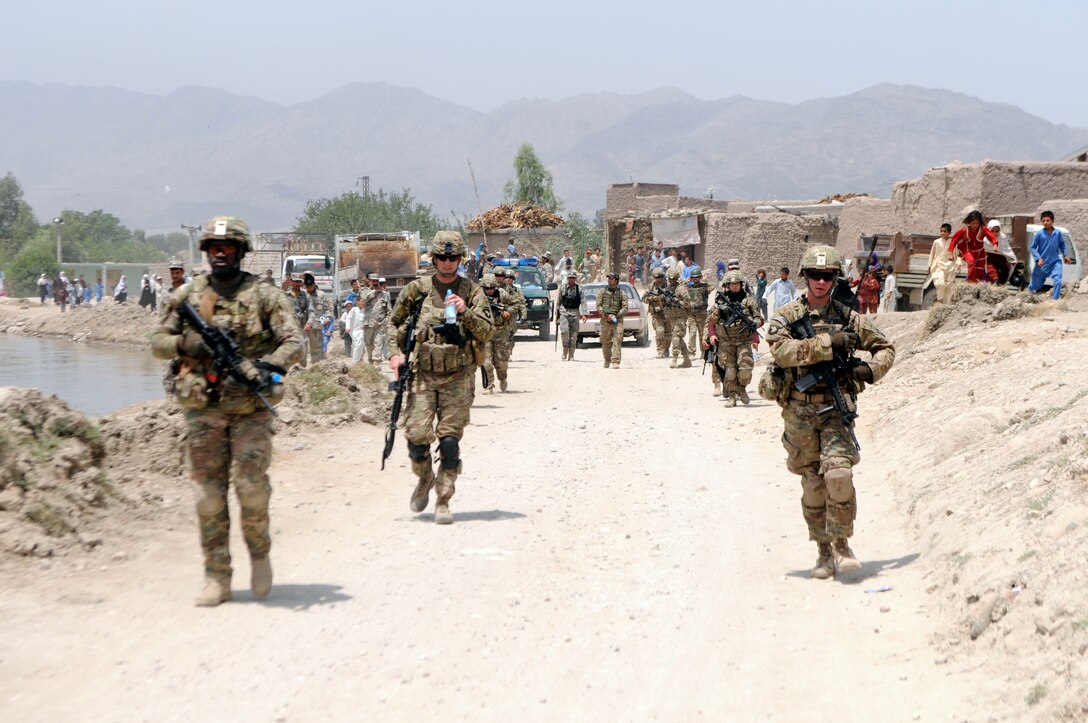 U.S. soldiers and Afghan border police patrol back to their base after successfully delivering school supplies to Afghan children in Jalalabad City in Afghanistan’s Nangarhar province, May 25, 2013.