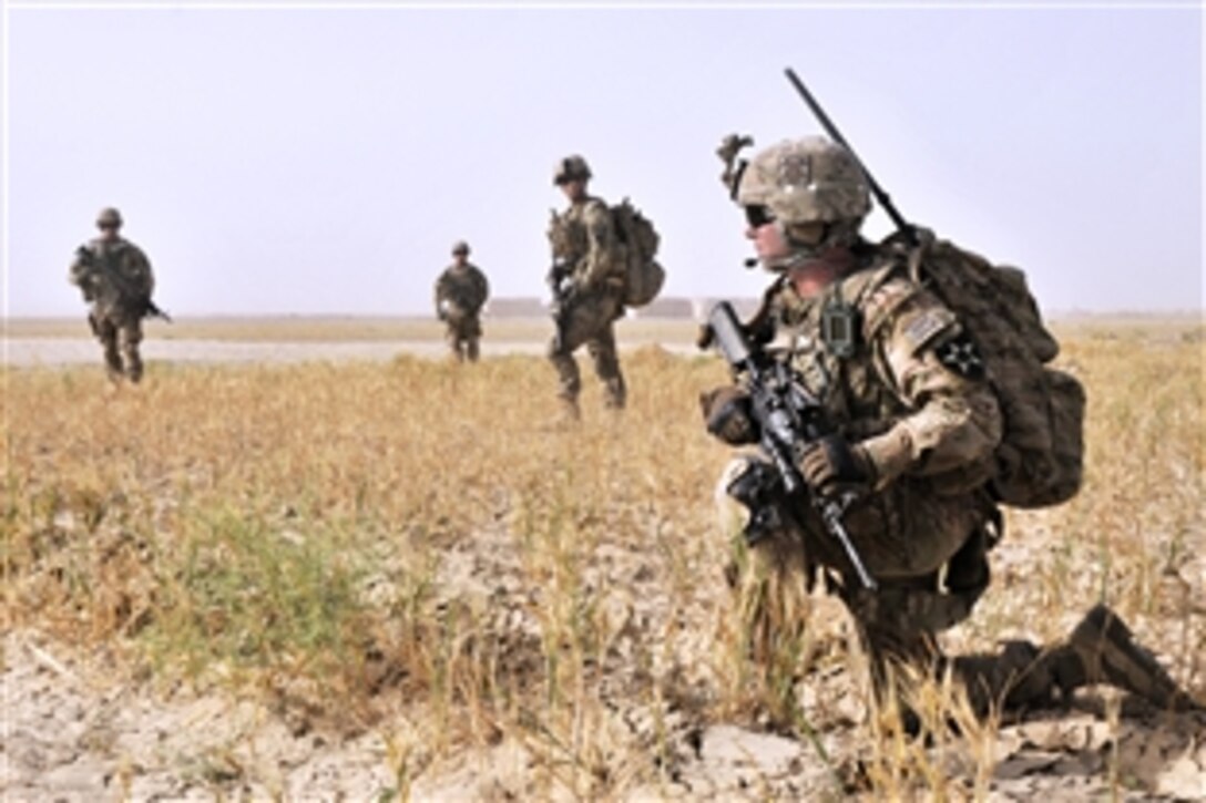 U.S. Army Spc. Jeremiah Carter, right, takes a knee while conducting a dismounted presence patrol with his soldiers near Forward Operating Base Spin Boldak in Kandahar province, Afghanistan, June 2, 2013. Carter is assigned to Company B, 2nd Battalion, 23rd Infantry Regiment. 
