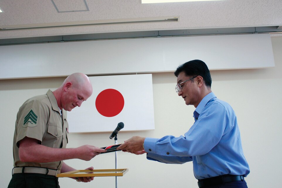 Sgt. Matthew P. Nelson bows as he accepts a letter of appreciation from Assistant Commissioner Chibana Kojun on behalf of the Okinawa City Police Headquarters May 30 at its headquarters. Nelson is the chief investigator with the accident investigation section of the Provost Marshal’s Office, Headquarters and Service Battalion, Marine Corps Base Camp Smedley D. Butler, Marine Corps Installations Pacific. Photo by Lance Cpl. Donald T. Peterson
