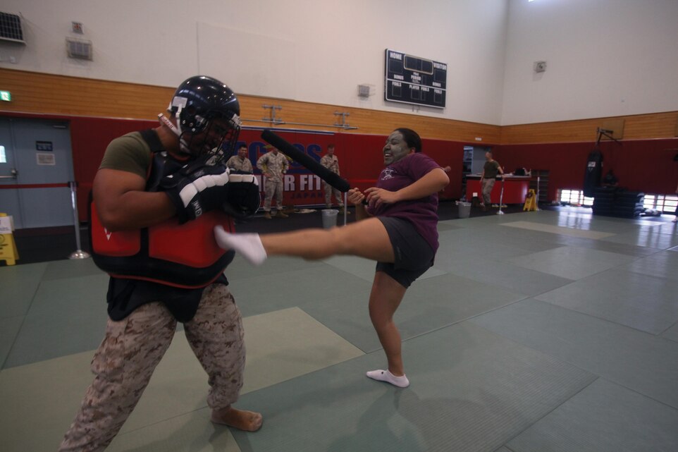 Maria P. Luna performs a defensive move against Sgt. Itsarayouth G. Tisapak while attending a Marine Corps martial arts program exhibition during 3rd Battalion, 12th Marine Regiment Jane Wayne Day May 31 at Camp Hansen. The Jane Wayne Day built cohesion among the spouses and increased their level of understanding of the Marine Corps, according to Staff Sgt. Mark A. Dorcemus,a field artillery cannoneer with 3rd Bn., 12th Marines,  3rd Marine Division, III Marine Expeditionary Force. Tisapak is a communications technician with the battalion, and Luna is the spouse of a sailor.Photo by Lance Cpl. Henry J. Antenor