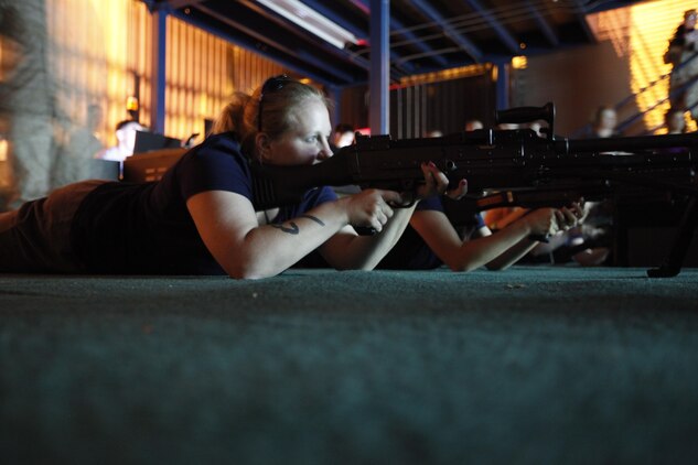 Amanda Gray, wife of Staff Sgt. Chance L. Gray, wire chief of Marine Wing Communications Squadron 28, prepares to engage virtual targets in a machine gun simulator during Jane Wayne Day May 30.