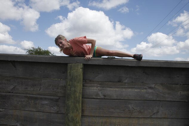 Erica Moralis, wife of Lance Cpl. Chandler Moralis, a technical controller with MWCS-28, climbs over a wall on the obstacle course during Jane Wayne Day May 30.