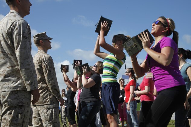 Wives of MWCS-28 Marines perform ammo can lifts during Jane Wayne Day.