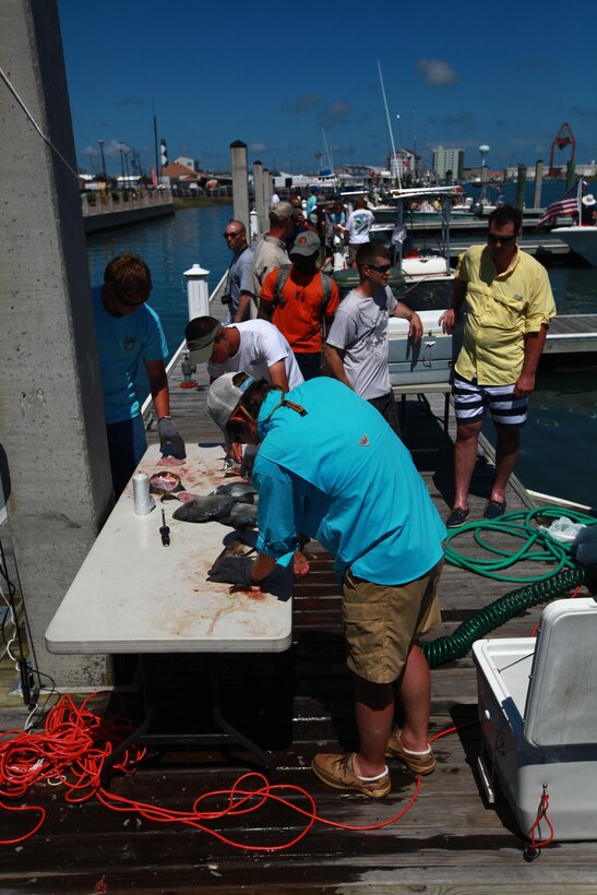 Active-duty service members line up to have their fish cleaned after a long day of fishing on the ocean during Military Appreciation Day  Saturday in Morehead City. More than 500 service members from duty stations throughout North Carolina attended the event to fish in the ocean’s open waters.