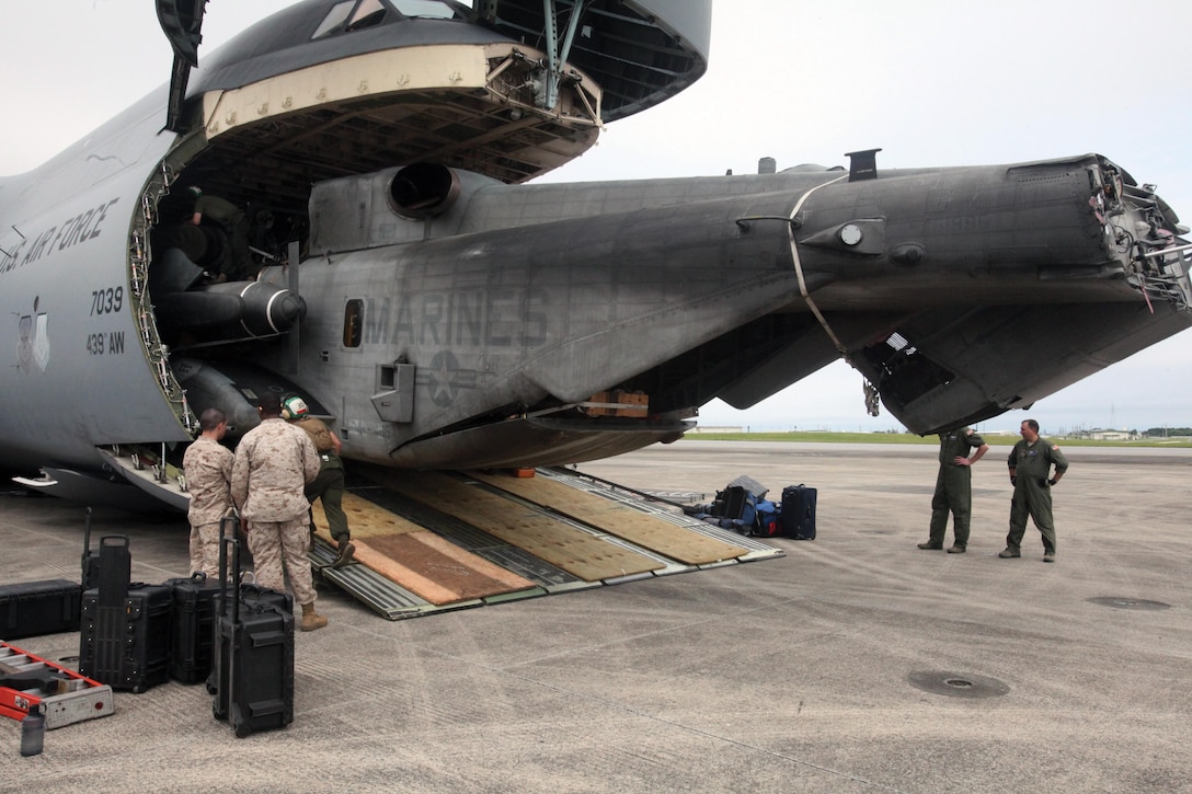 A CH-53E Super Stallion helicopter exits the front of an opened C-5 Galaxy cargo aircraft June 3 on the Marine Corps Air Station Futenma flight line. The aircraft is part of an aviation detachment in Okinawa that is being reestablished under the unit deployment program. The commandant of the Marine Corps established the UDP in October 1977 to provide for the deployment of units to the Asia-Pacific region for periods of approximately six months. With the recent reduction of forces deployed to U.S. Central Command, the Marine Corps is resuming the regular UDP cycle of units rotating from U.S. home stations. The CH-53E is with Marine Heavy Helicopter Squadron 772, Marine Aircraft Group 49, 4th Marine Aircraft Wing, U.S. Marine Corps Forces Reserve, currently assigned to 1st MAW under the UDP. The C-5 is with the 337th Airlift Squadron, 439th Operations Group, 439th Airlift Wing, 22nd Air Force, Air Force Reserve Command.
Photo by Cpl. Alyssa N. Gunton
