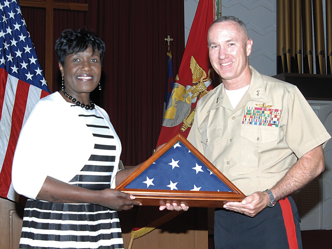 Debra Moore Capers retires from Marine Corps Logistics Command after more than 35 years of service. Maj. Gen. Charles Hudson, commanding general, MCLC, presented her with an American flag during the ceremony, May 30, at the Chapel of the Good Shepherd, here. 