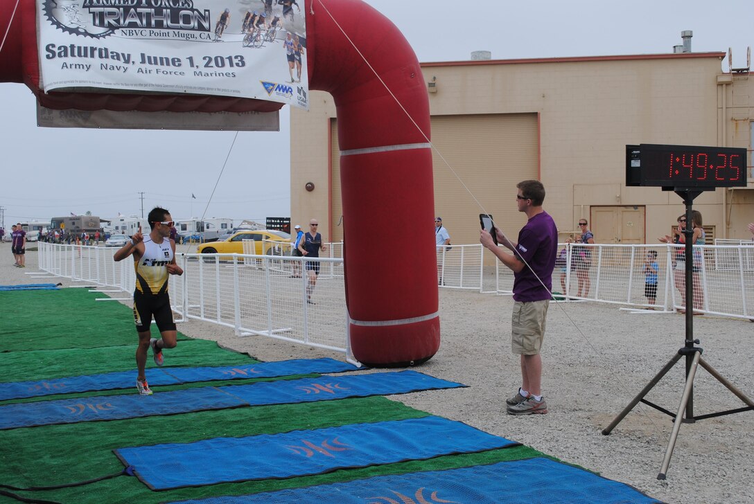 Army Capt. Nicholas Sterghos of Fort Hood, Texas, gestures as he finishes the Armed Forces Triathlon in first place June 1 at Naval Base Ventura County, Point Mugu, Calif. Sterghos, who finished with a time of 1 hour, 49 minutes, 21 seconds, finished second in last year's race.
