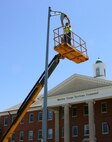 Mike Serio, an electrician with Commercial Power Inc., installs light-emitting diode, or LED, lights outside Marine Corps Systems Command’s Bldg. 2200 at Marine Corps Base Quantico, Va., June 4. The LED light installation is part of the base’s ongoing efforts to save money through reduced energy use. 