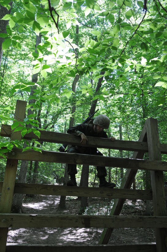 A Naval Academy midshipman prepares to hoist himself over an obstacle on The Basic School’s endurance course May 31, at the outset of the Leatherneck training that will help the Marine Corps select more than 200 future officers. 