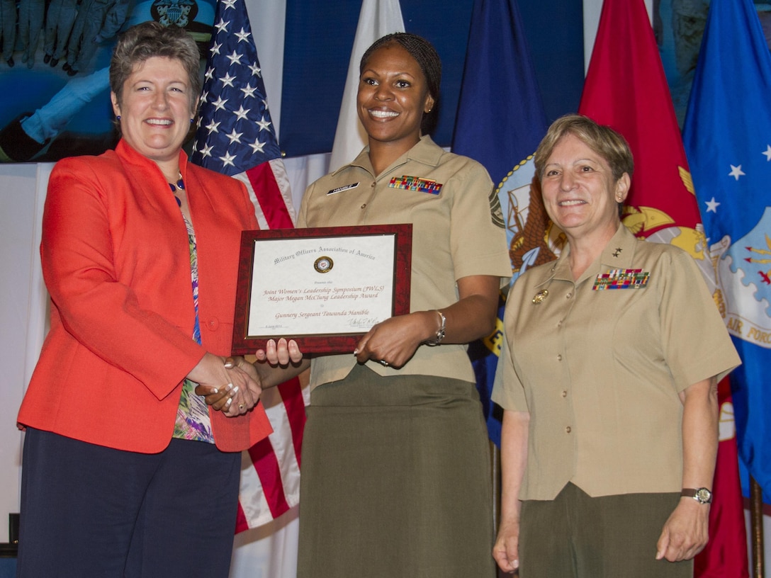 Gunnery Sgt. Tawanda Hanible, diversity operations chief, Marine Corps Recruiting Command, is presented the Major Megan McClung Leadership Award by Coast Guard Rear Admiral Cari B. Thomas (left) and Maj. Gen. Angela Salinas, director, Manpower Management Division, during the Joint Womens Leadership Symposium at the Gaylord National Resort and Conference Center today. The Major Megan McClung Leadership Award, named after the first female Marine officer killed in Iraq, recognizes Marines who display 'inspirational, innovative and imaginative leadership.' 