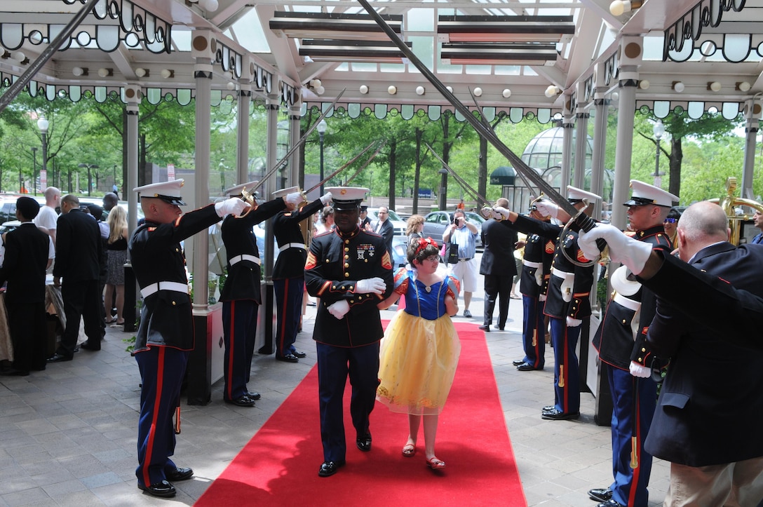 Sgt. Kofa Freeman, a sergeants course student, escorts Anna Reese of Vienna, Va., through the arch of swords and into the Willard InterContinental Hotel at the start of “A Cinderella Ball” on June 2, 2013. The annual event, staged by The House Inc., is for children of military families who have disabilities or life-threatening illnesses. Freeman and the other Marines are from the Sergeants Course at Quantico’s Staff Noncommissioned Officers Academy. 