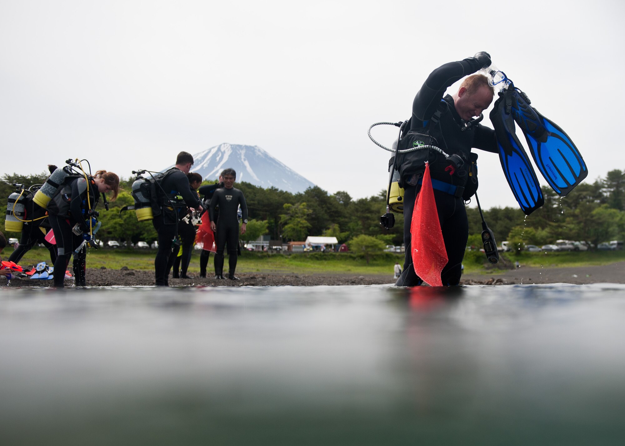 LAKE MOTOSU, Japan -- Maj. John Chrampanis, Yokota Air Base Dive Club member, readies his gear before a scuba dive at Lake Motosu, Japan, June 1, 2013. Chrampanis was one of seven divers from Yokota, and one of 80 overall participants, who volunteered to help remove debris from Lake Motosu. (U.S. Air Force photo by Senior Airman Cody H. Ramirez)