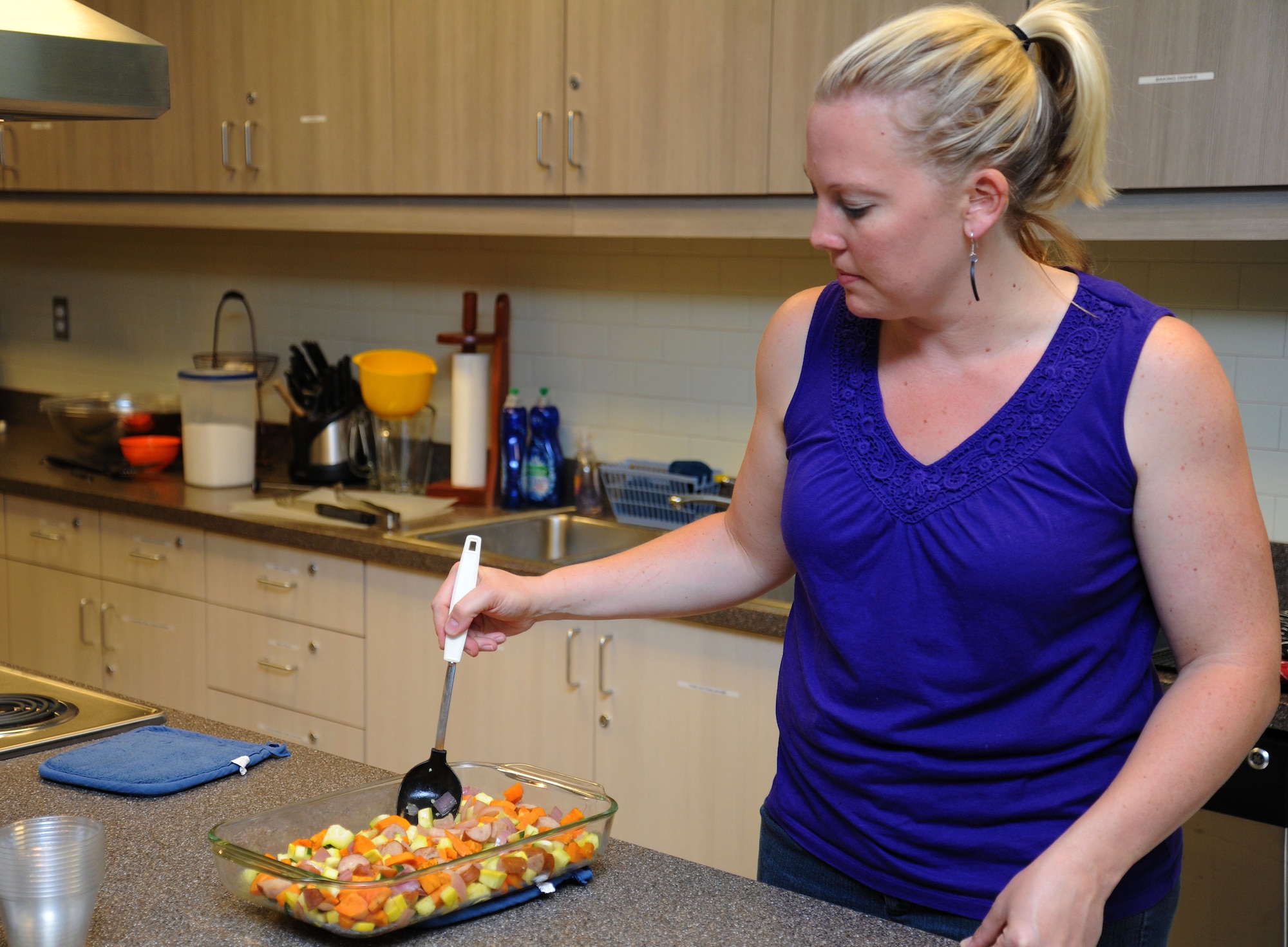 Alyson Kresser, 92nd Aerospace Medicine Squadron Health and Wellness Center registered dietitian serves roasted vegetables and sausage during the Health and Wellness Center's healthy cooking class.(U.S. Air Force photo by 2nd. Lt. Rachelle Smith/Released)