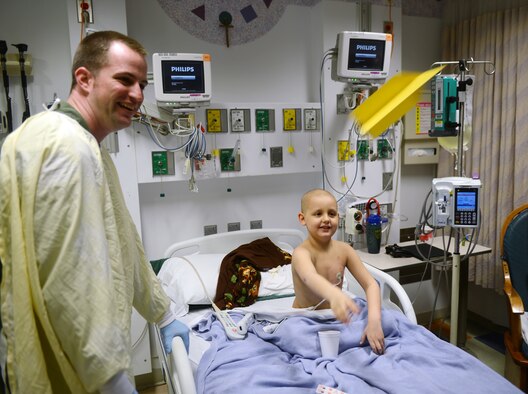 JOINT BASE ELMENDORF-RICHARDSON, Alaska -- Air Force Capt. Christopher Ferguson, 517th Airlift Squadron pilot, crafts paper airplanes with Dominic Burns at Providence Childrens Hospital May 22. The Providence Children's Hospital has the only pediatric clinic in Alaska and serves children from all over state. (U.S. Air Force photo/Airman Ty-Rico Lea)