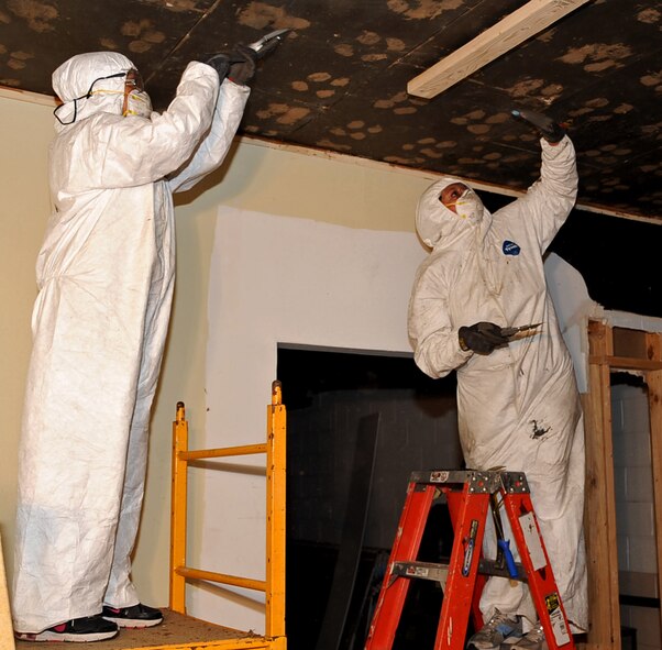 Master Sgt. Editha Decuir, left, and Tech. Sgt. Starlight Lesher, Barksdale Global Power Museum staff, remove glue during from a museum room renovation at Barksdale Air Force Base, La., May 30, 2013.  Three out of seven rooms at the museum are being renovated for new exhibits. (U.S. Air Force photo/Staff Sgt. Jason McCasland)