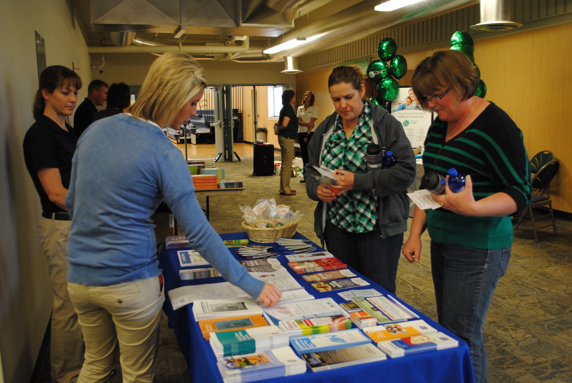 Jacqueline Maillet, 341st Force Support Squadron Health and Wellness Center dietician (far left), and Jennifer McMullen, 341st FSS HAWC health promotion manager, show Carla Bernard, 341st Civil Engineer Squadron field scheduler (right center), and Candace Ellsworth, 341st CES engineer, brochures of information about programs the HAWC offers to members on base.  The HAWC was one of several different on-base agencies that attended the Health and Wellness Fair at the fitness center May 29. (U.S. Air Force photo/Senior Airman Cortney Paxton)