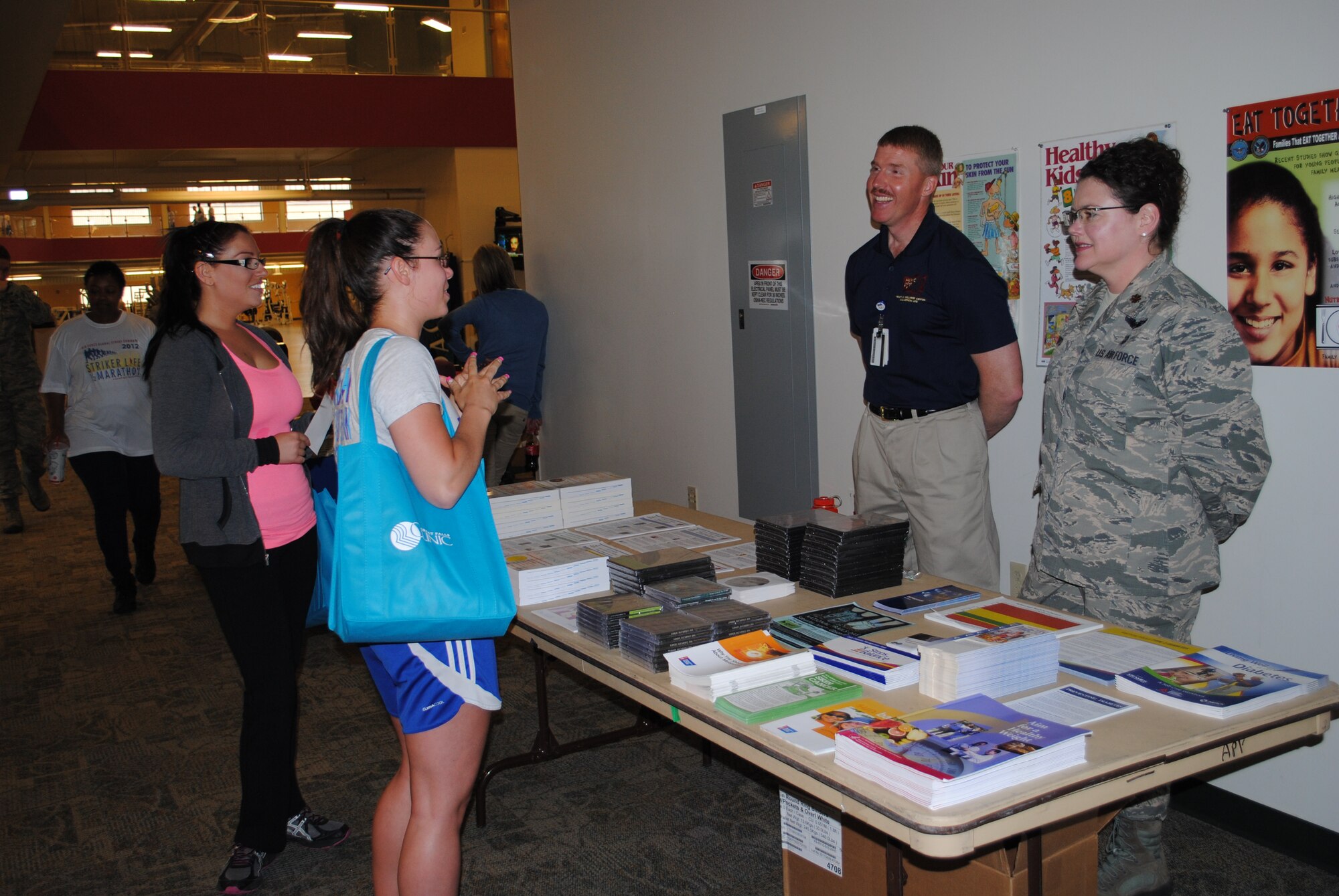 Maj. Ingrid Ford, 341st Medical Group health care integrator, and Kirk Clark, 341st Medical Operations Squadron Health and Wellness Center exercise physiologist, talk to Amanda Linebacker, far left, and Morgan Tucker, both Malmstrom dependents, about the HAWC during the Health and Wellness Fair on May 29.  Informational booths, physical fitness activities and free prizes were available for those who attended.  (U.S. Air Force photo/Senior Airman Cortney Paxton)