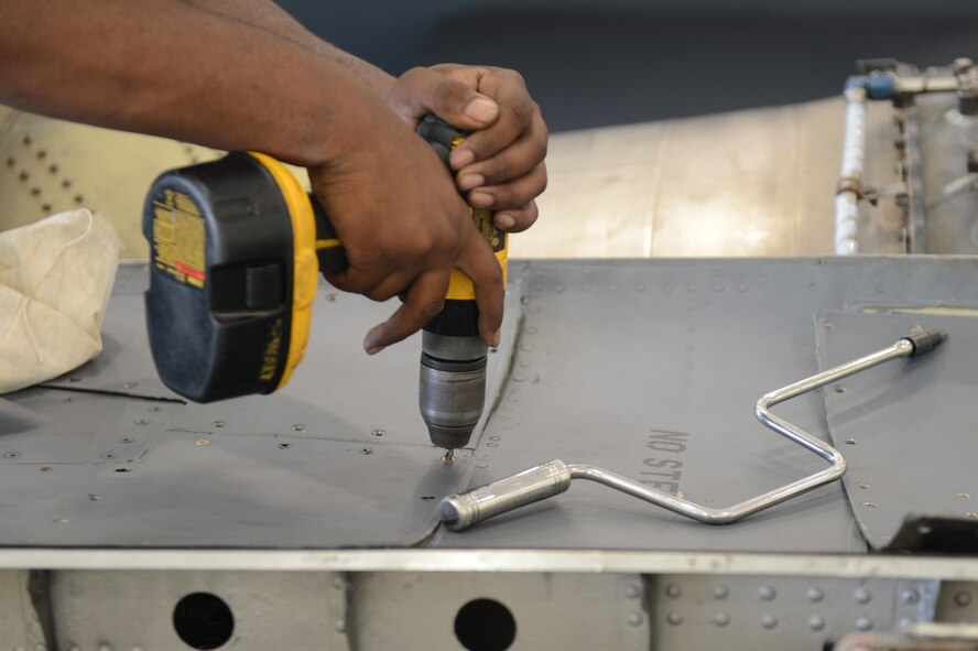 Airman 1st Class Mikel Stephens, 2nd Maintenance Squadron, secures a panel to an engine pod in the Phase Hangar on Barksdale Air Force Base, La., June 5, 2013. The panels are removed during a phase inspection so Airmen can looking for loose hard ware or other discrepancies. (U.S. Air Force photo/Senior Airman Micaiah Anthony)