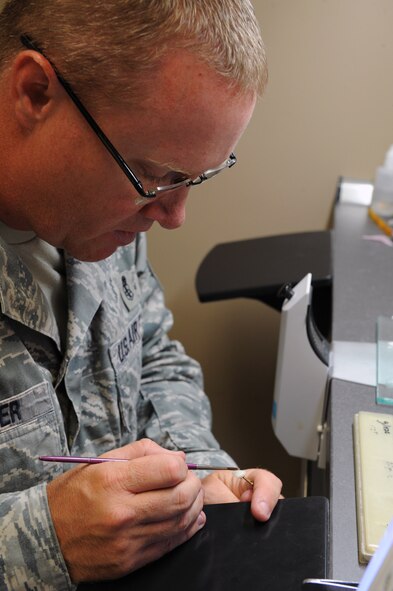 Master Sgt. Denny Shaffer, 2nd Dental Squadron dental laboratory flight chief, glosses a crown on Barksdale Air Force Base, La., June 6, 2013. The crown is glossed so it can resemble the look of an actual tooth. (U.S. Air Force photo/Airman 1st Class Benjamin Gonsier)