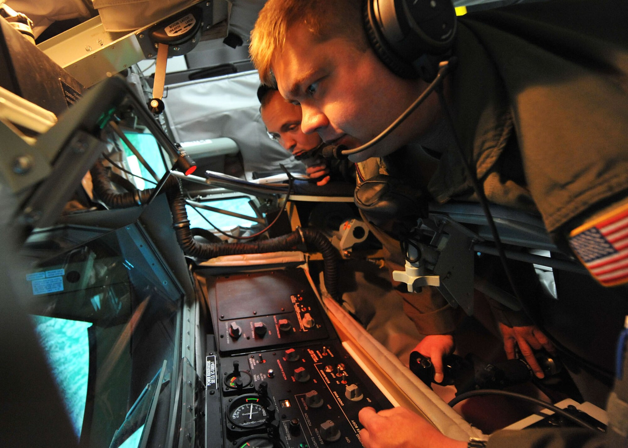 (Left to right) Senior Airman James Michel and Tech. Sgt. Jason Burianek, 384th Air Refueling Squadron boom operators, use a KC-135 Stratotanker Boom Operator Weapon System Trainer to simulate in-flight refueling, June 5, 2013 at McConnell Air Force Base, Kan. This technology is currently available at three Air Force bases, with additional systems scheduled to be installed throughout the Air Force this year. With an operating cost of roughly $700, the BOWST drastically cuts down costs compared to an eight hour tanker sortie at $49,000, while helping McConnell’s operators to focus on student qualification requirements, emergency procedures, and meet their global air refueling mission. (U.S. Air Force photo/ Staff Sgt. Jess Lockoski) 