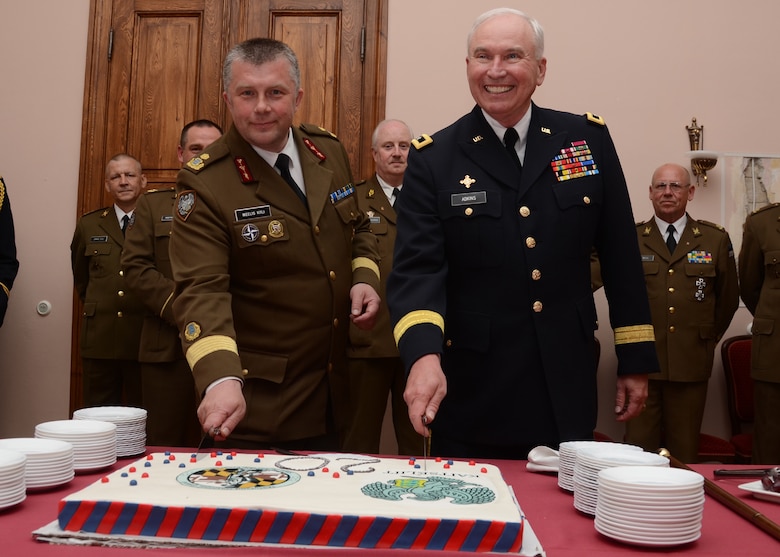 U.S. Army Maj. Gen. James Adkins, The Adjutant General, Maryland NationalGuard and Estonian Brig. Gen. Meelis Kiili, Commander of the Estonia Defense League prepare to cut an anniversary cake at Alu Manor in Raplamaa, Estonia is the site for the 20th anniversary celebration state partnership program between the Estonian Military and the Maryland National Guard on June 4, 2013.  Maj. Gen. Adkins traveled to Estonia to celebrate this accomplishment during Sabre Strike 2013.  Saber Strike 2013 is a U.S. Army Europe-led, multinational, tactical field training and command post exercise occurring in Lithuania, Latvia and Estonia June 3-14 that involves more than 2,000 personnel from 14 different countries. The exercise trains participants on command and control as well as interoperability with regional partners and is designed to improve  joint, multinational capability in a variety of missions and to prepare participants to support multinational contingency operations worldwide. (U.S. Air National Guard photo by Staff Sgt. Benjamin Hughes)