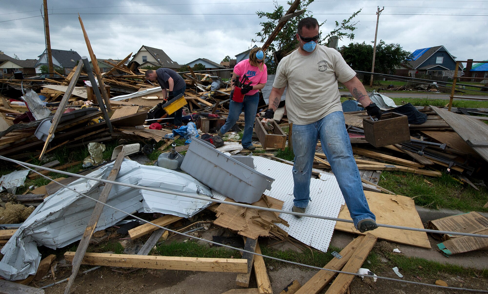 Staff Sgt. Michael Swank, a flight engineer, Staff Sgt. Jennifer Umbach, also a flight engineer, and Senior Airman Stephen Lucadello, a load master, all with the 9th Airlift Squadron, Dover Air Force Base, Del., salvage items from the home of Tech. Sgt. Rhonda Stockstill in Moore, Okla., on May 27, 2013. Stockstill, whose home was destroyed in the May 20 EF-5 tornado that ripped through Moore, Okla., is a surgery technician with the 72nd Medical Group, Tinker AFB, Okla. Umbach, Swank, and Lucadello traveled more than 36 hours from Dover AFB, Del., to help victims of the tornado. Swank is from Tampa, Fla., Umbach is from Jackson, Wis., and Lucadello is from Union City, Calif. (U.S. Air Force photo by Tech. Sgt. Bradley C. Church)