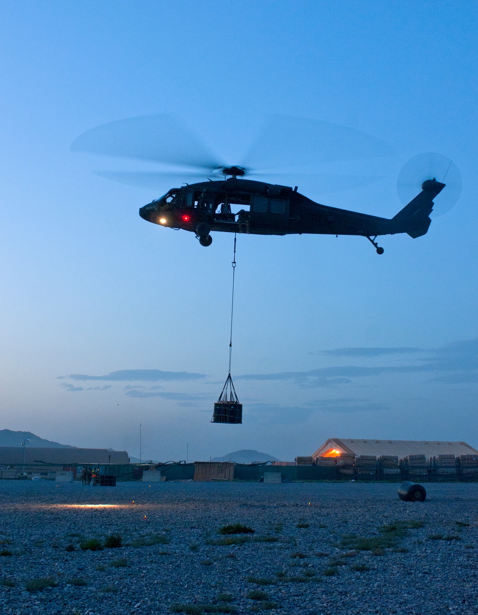 A UH-60 Black Hawk helicopter takes a 1,800 pound A-22 cargo bag away after an in-flight cargo sling-load is executed during a joint-coalition sling load training mission at Kandahar Airfield, Afghanistan, June 1, 2013. The training provided coalition members the opportunity to learn the concepts of marking and illuminating a landing zone as well as in-flight cargo sling loading. (U.S. Air Force photo/Capt. Brian Maguire)