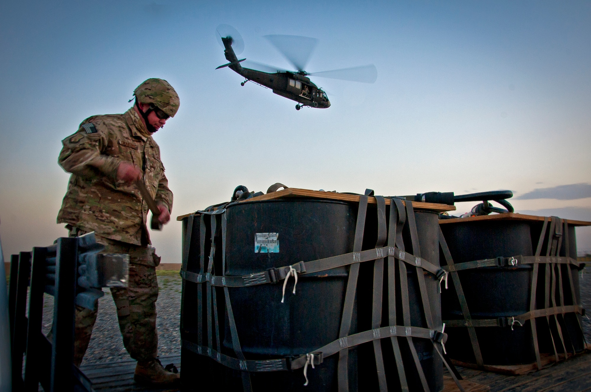 U.S. Air Force Senior Master Sgt. Gwen Crabtree, 451st Expeditionary Logistics Readiness Squadron, prepares an A-22 cargo bag before a UH-60 Black Hawk helicopter conducts an in-flight cargo sling load during a joint-coalition training mission at Kandahar Airfield, Afghanistan, June 1, 2013. The training provided coalition members the opportunity to learn the concepts of marking a landing zone as well as in-flight cargo sling loading. (U.S. Air Force photo/Senior Airman Scott Saldukas)