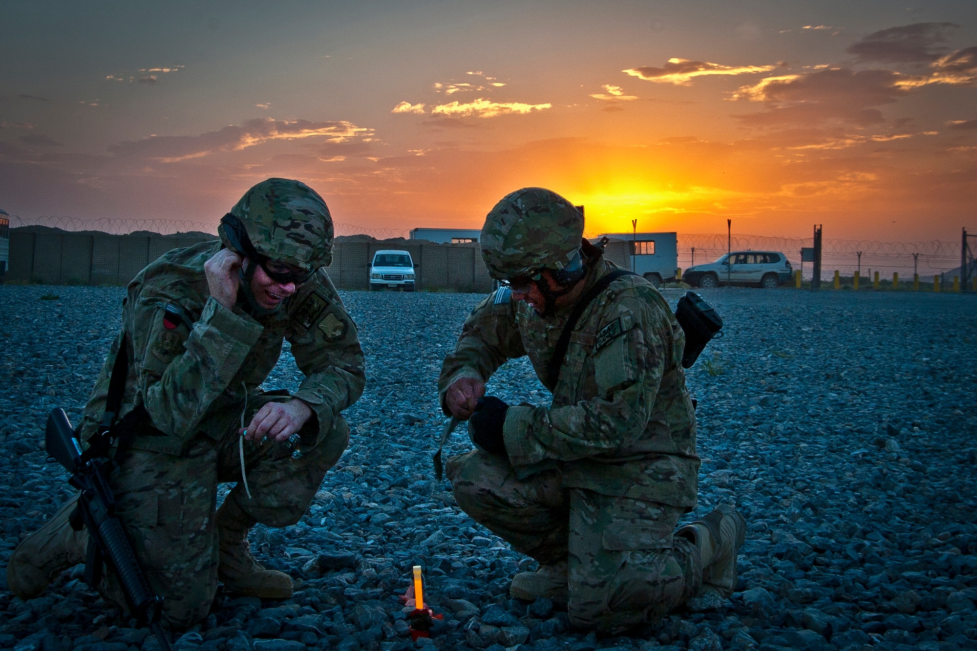 U.S. Air Force Senior Airman David Hales and Tech. Sgt. Michael Docodcil, both with the 451st Expeditionary Logistics Readiness Squadron, emplace chemical lights to illuminate a helicopter landing zone for a UH-60 Black Hawk during a joint-coalition sling load training mission at Kandahar Airfield, Afghanistan, June 1, 2013. The training provided coalition members the opportunity to learn the concepts of illuminating a landing zone as well as in-flight cargo sling loading. (U.S. Air Force photo/Senior Airman Scott Saldukas)