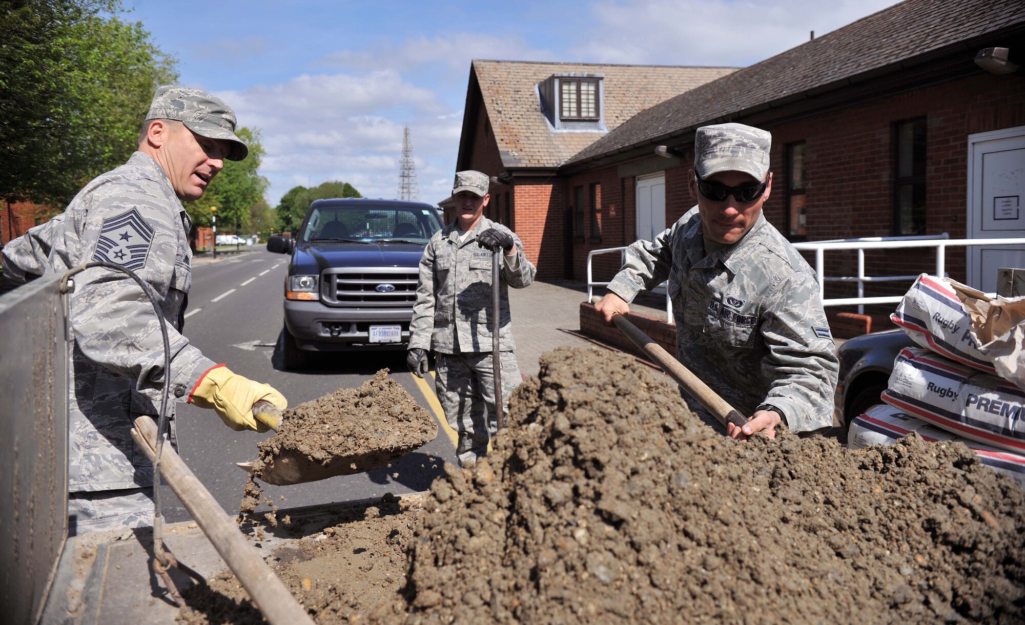From right, Airman 1st Class Steven Beasley, 100th Civil Engineer Squadron Horizontal Shop pavements and construction equipment journeyman from Roseville, N.C., Staff Sgt. Tyler Meiers, 100th CES Horizontal Shop pavements and construction equipment craftsman from Armour S.D., and Chief Master Sgt. Tracy Jones, 100th Air Refueling Wing command chief, use concrete to repair a drain pot June 5, 2013, on RAF Mildenhall, England. Drain repairs are crucial to combating soil contamination, water pollution and soil erosion within the sub-surface drainage system. (U.S. Air Force photo by Staff Sgt. Jerilyn Quintanilla/Released) 