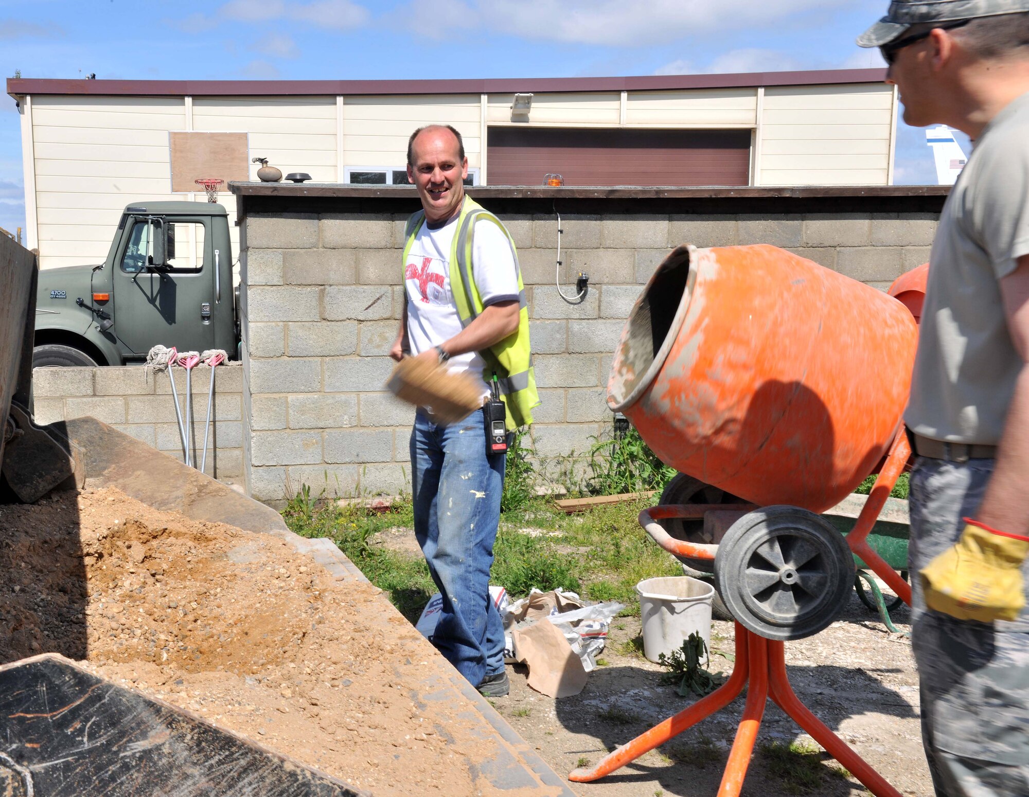 Richard Austin, 100th Civil Engineer Squadron Horizontal Shop master brick layer from Mildenhall, England, explains the process of mixing concrete to Chief Master Sgt. Tracy Jones, 100th Air Refueling Wing command chief, June 5, 2013, on RAF Mildenhall, England. The 100th CES Horizontal Shop uses concrete mixed on site to repair sidewalks, the airfield and broken drain pots. (U.S. Air force photo by Staff Sgt. Jerilyn Quintanilla/Released)