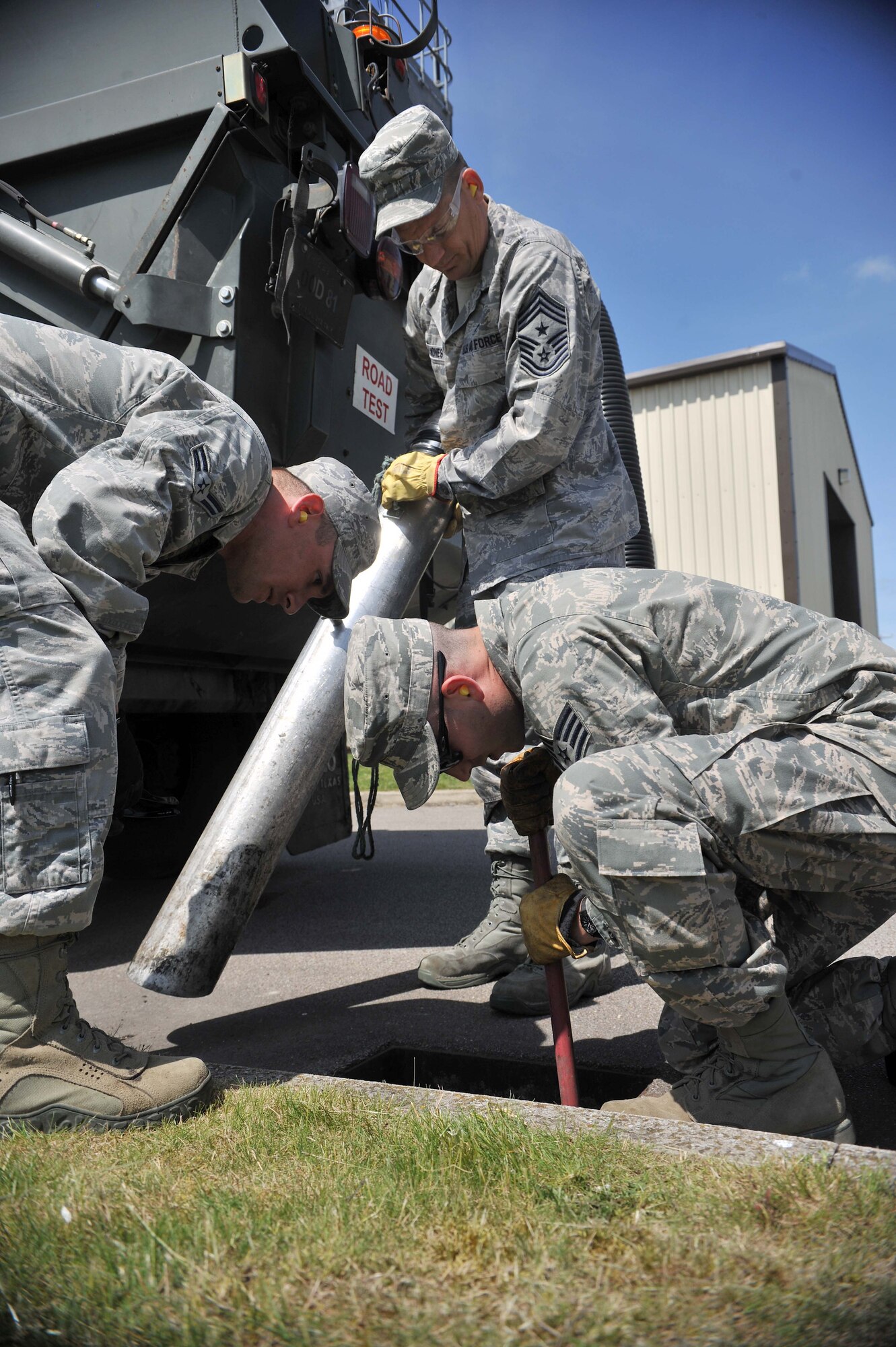 From left, Airman 1st Class Steven Beasley, 100th Civil Engineer Squadron Horizontal Shop pavements and construction journeyman from Roseville, N.C., Chief Master Sgt. Tracy Jones, 100th Air Refueling Wing command chief, and Staff Sgt. Jack DeMato, 100th CES Horizontal Shop pavements and construction craftsman from Montana City Mont., pavements and construction equipment craftsman, inspect a drain for debris June 5, 2013, on RAF Mildenhall, England. In addition to maintaining the base’s sub-surface drainage system, the 100th CES Horizontal Shop conducts sweeper operations and snow removal ensuring the runway is safe for aircraft take-off and landing. (U.S. Air Force photo by Staff Sgt. Jerilyn Quintanilla/Released)