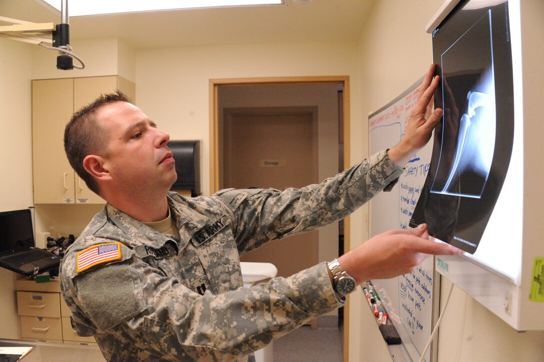 Army Capt. David Rowland, veterinarian, looks at an X-ray at the Kirtland veterinary clinic. Rowland will be leaving the clinic in July, forcing a temporary reduction in clinic services.