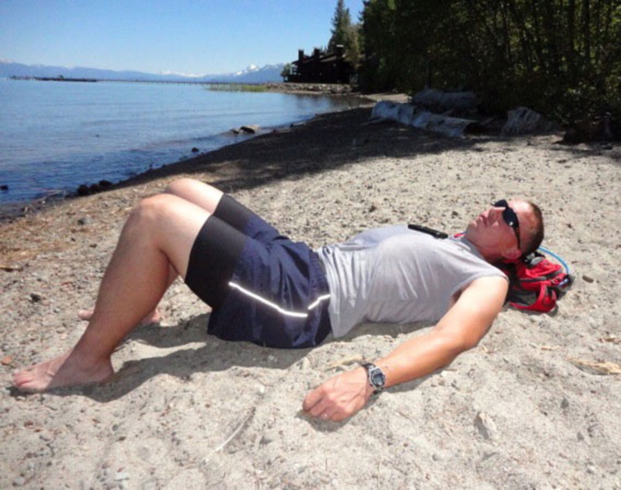 TRAVIS AIR FORCE BASE, Calif. -- Tech. Sgt. Timothy Covey, 60th AMXS, grabs a short rest along the shore of Lake Tahoe, during the 2013 Reno-Tahoe Odyssey. Covey joined 11 other Travis AFB maintainers, both active and reserve, to run this 178-mile relay race that winds its way around the lake, beginning and ending in Reno, Nev. (U.S. Air Force photo/Senior Master Sgt. Randy Robb)