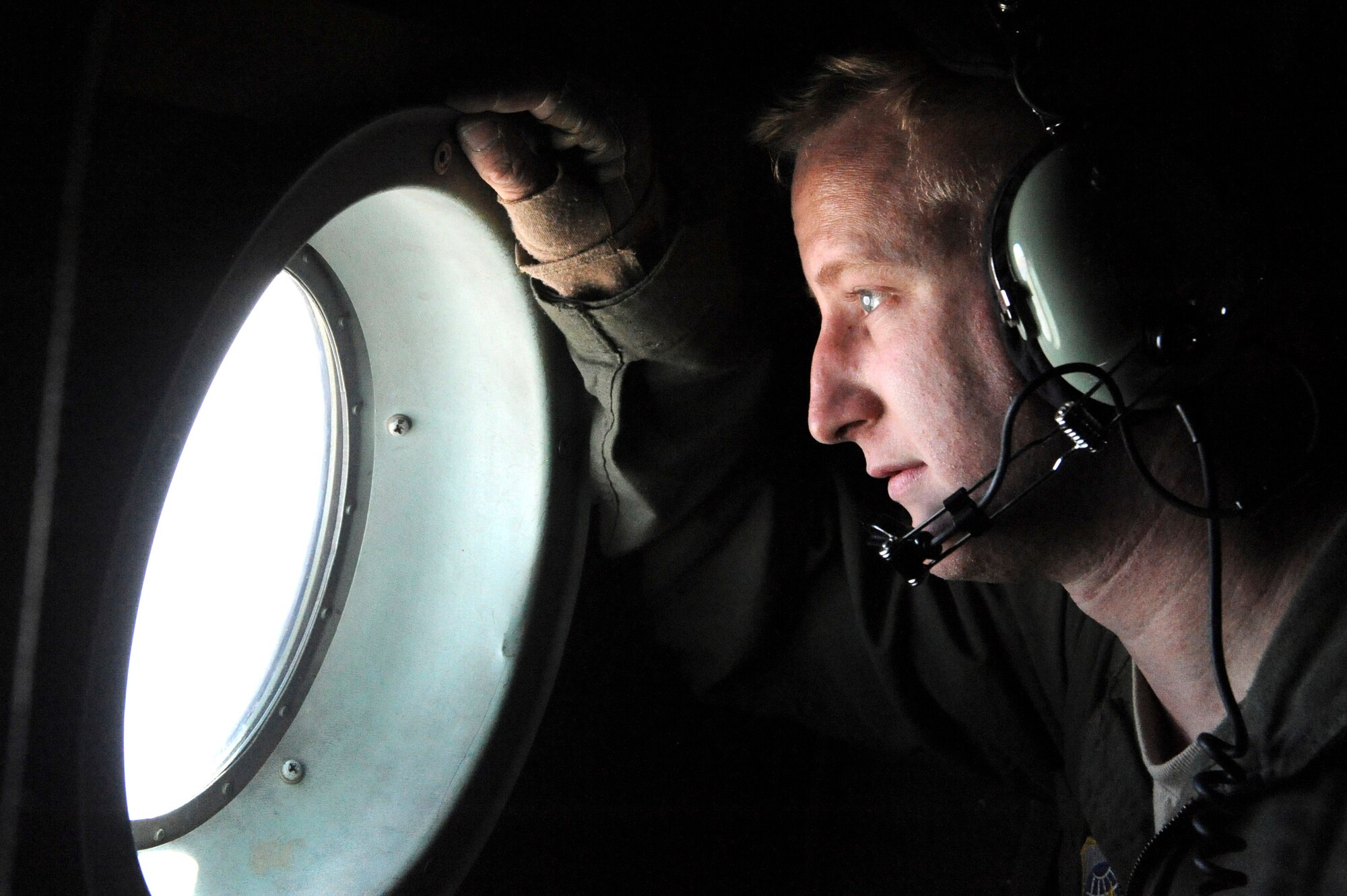 Airman 1st Class Timothy Manzer, a 53rd Airlift Squadron loadmaster, looks through a porthole of a C-130 after Operation Joint Forcible Entry May 31, 2013, at Little Rock Air Force Base, Ark. Operation Joint Forcible Entry was an exercise that tested the Air Force's capability for tactical airlift. (U.S. Air Force photo by Senior Airman Rusty Frank)