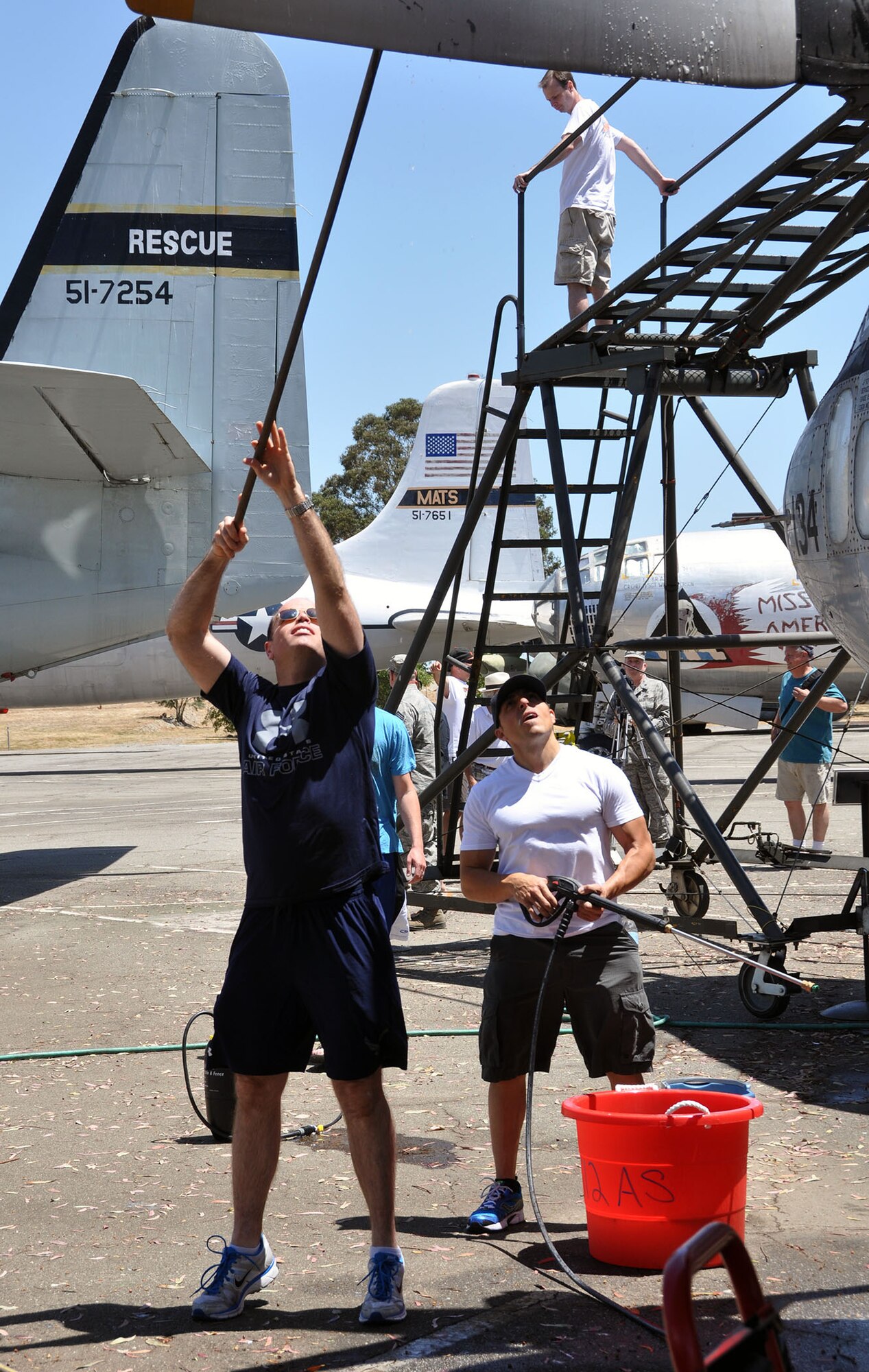 TRAVIS AIR FORCE BASE, Calif. -- Senior Master Sgt. Mark Eger, First Sergeant,  holds a pressure washer as Staff Sgt. Jared Bayer a C-5 loadmaster, scrubs the wing of a C-119. Eger and Bayer are both part of the 312th Airlift Squadron which recently adopted the C-119. The unit flew C-119s from 1958 to 1966 and adopting this plane was a way for the unit to learn about its heritage. (U.S. Air Force photo / Senior Airman Cindy G. Alejandrez)