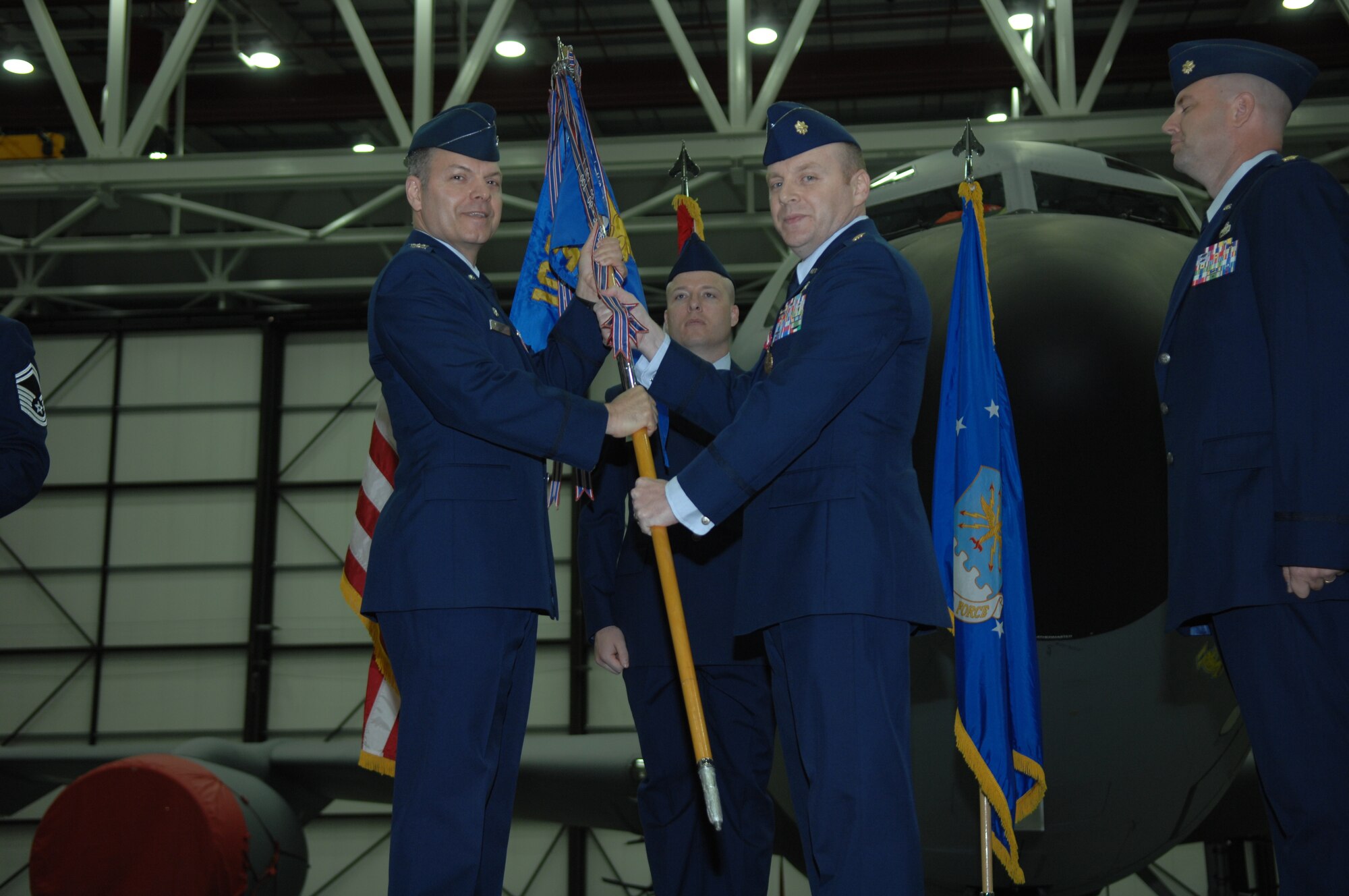 From left, Col. Joseph Rushlau, 100th Maintenance Group commander, receives the 100th Maintenance Squadron guidon from Maj. Donny Bagwell, 100th MXS commander, during the 100th MXS Change of Command ceremony June 6, 2013, in Hangar 814 on RAF Mildenhall, England. Bagwell is assuming command of the 386th Expeditionary Aircraft Maintenance Squadron in Southwest Asia. (U.S. Air Force photo by Airman 1st Class Dillon Johnston/Released)