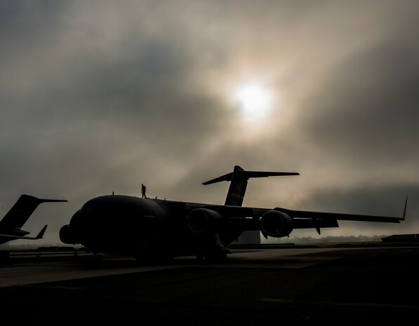 Tech. Sgt. Andrew Gravett, 437th Aircraft Maintenance Squadron crew chief, walks along the top of a C-17 Globemaster III while wearing a safety harness as he does a routine maintenance check of the aircraft June 4, 2013, at Joint Base Charleston – Air Base, S.C. The first C-17 to enter the Air Force’s inventory arrived at Charleston Air Force Base in June 1993. The C-17 is capable of rapid strategic delivery of troops and all types of cargo to main operating bases or directly to forward bases in the deployment area. (U.S. Air Force photo/Senior Airman Dennis Sloan)