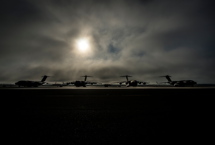 Fog rolls across the Joint Base Charleston flightline as the sun rises above four C-17 Globemaster III’s June 4, 2013, at JB Charleston – Air Base, S.C. The first C-17 to enter the Air Force’s inventory arrived at Charleston Air Force Base in June 1993. The C-17 is capable of rapid strategic delivery of troops and all types of cargo to main operating bases or directly to forward bases in the deployment area. (U.S. Air Force photo/Senior Airman Dennis Sloan)